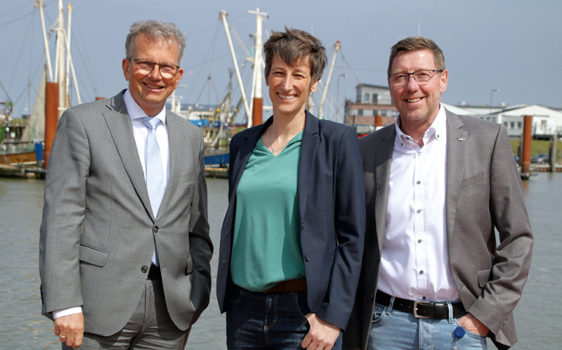 Holger Banik, Katrin Büscher und Friedrich Voß vor einer maritimen Kulisse