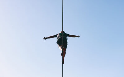 Mensch balanciert auf einem Drahtseil