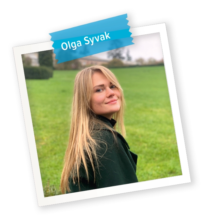 Porträt von Olga Syvak in einem Polaroidformat, sie schaut über ihre rechte Schulter nach hinten in die Kamera und läuft auf einer grünen Wiese