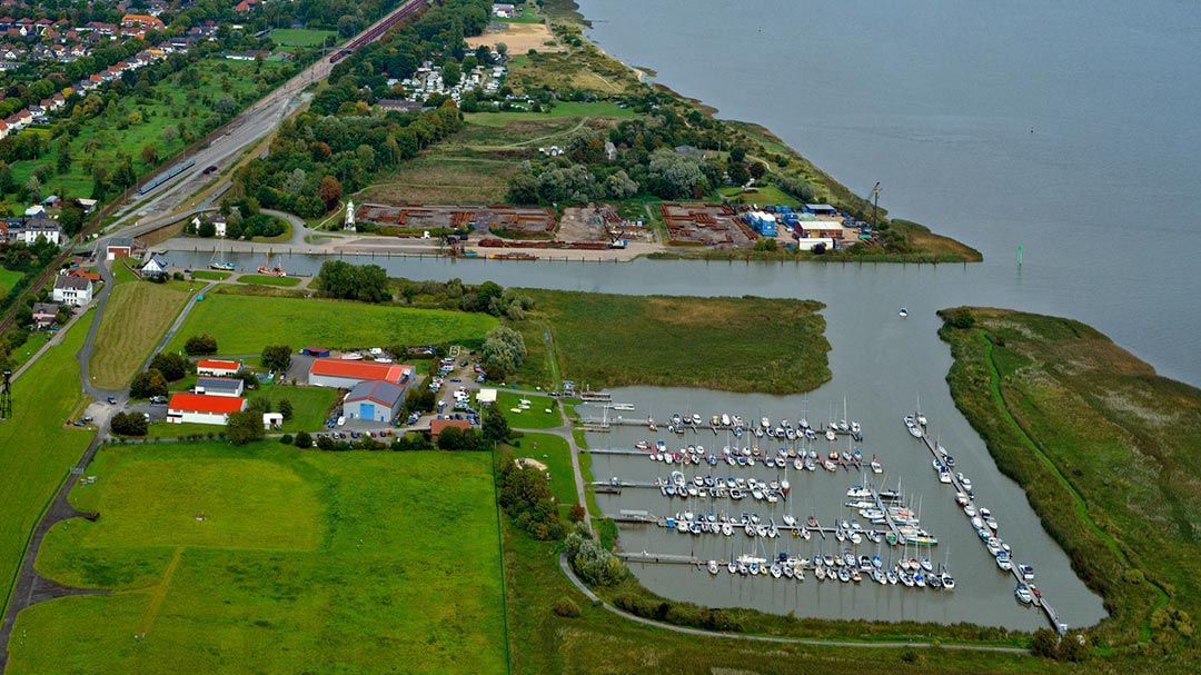 Aerial view of the Großensiel harbor with a sailing boat marina in the foreground.