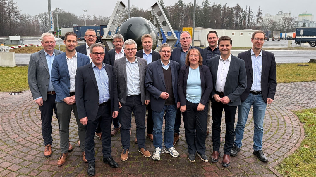 Eine Gruppe von dreizehn Personen hat sich zu einem Gruppenfoto eingefunden