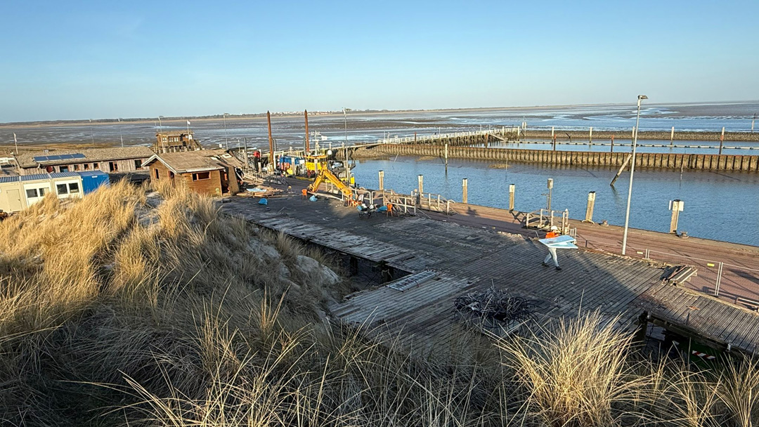 Blick auf den Hafen Wangerooge an dem Bautätigkeiten zu erkennen sind.