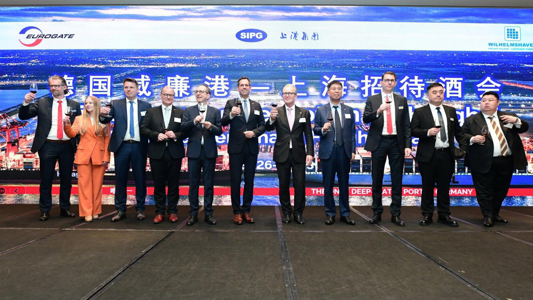 Eleven people, including a delegation from Germany and the Chinese hosts, raise their glasses to the camera