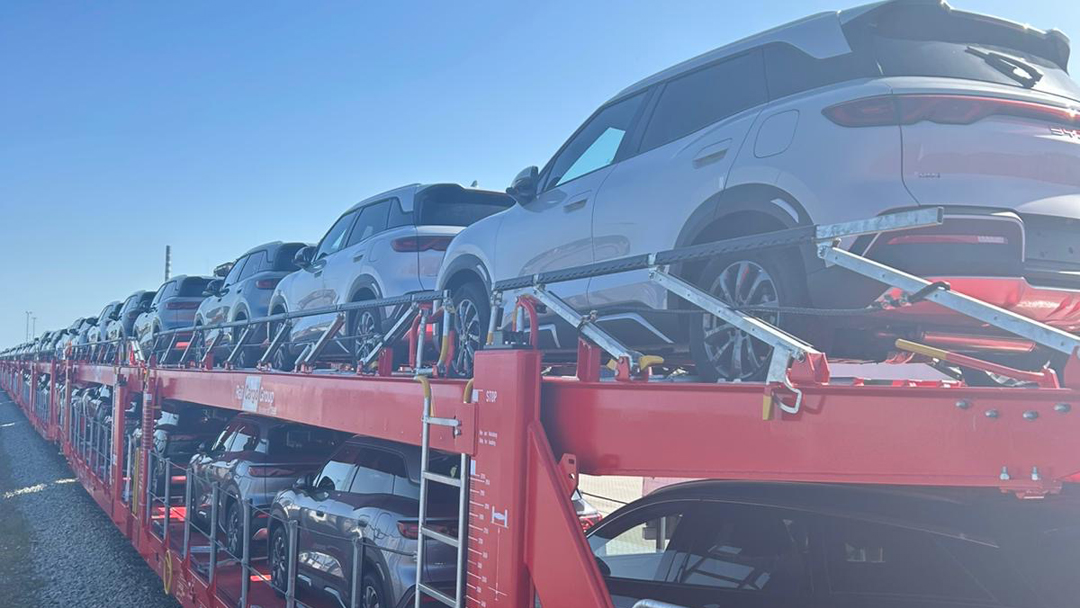 Ein roter Autozug, voll beladen mit Fahrzeugen