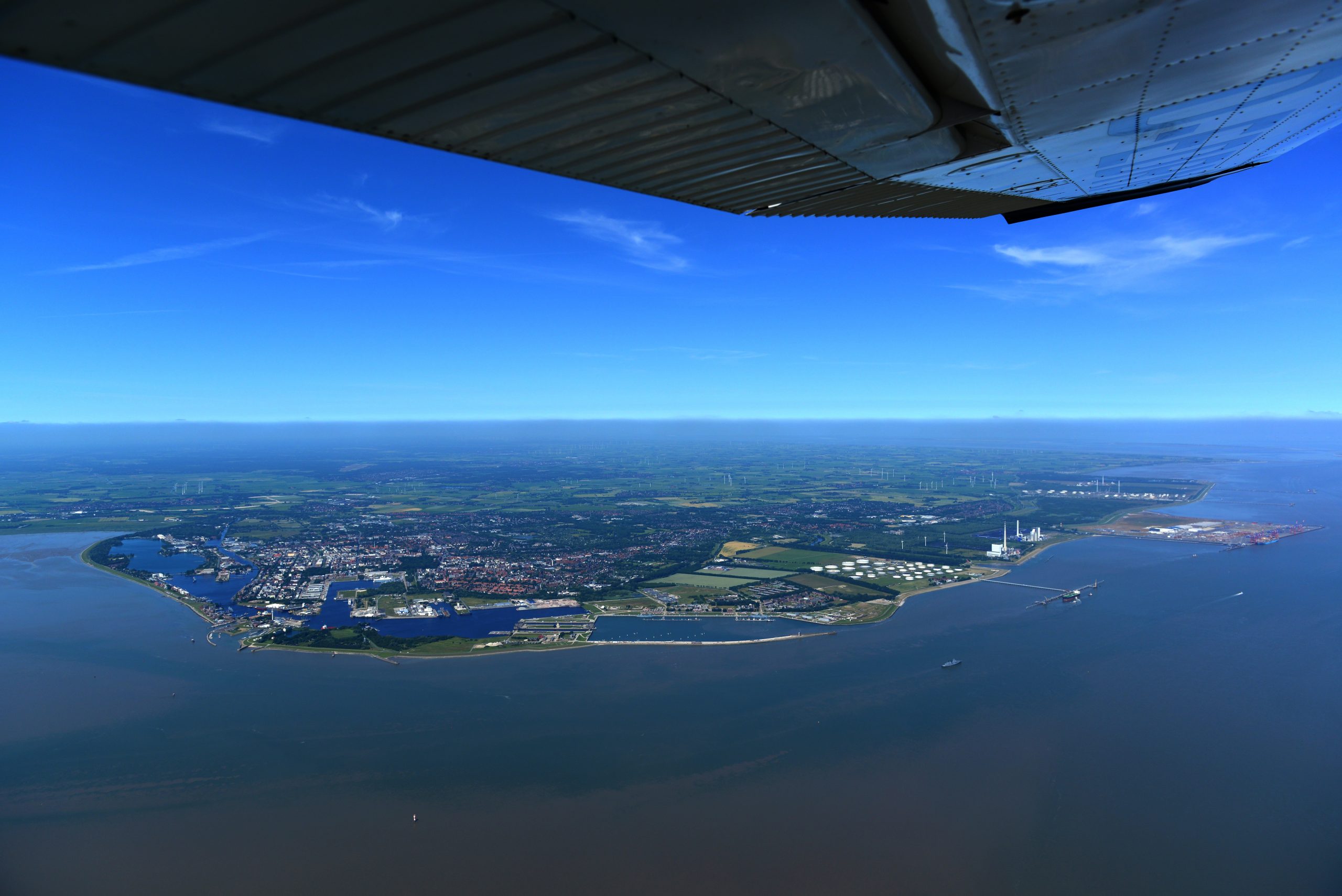 Luftaufnahme des Hafens in Emden bei strahlend blauem Himmel
