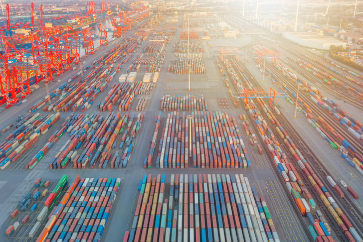 Blick auf ein Containerterminal mit zahlreichen aufgereihten bunten Containern.