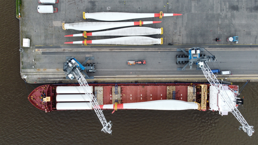 Verladung von vier Rotorblättern auf ein Schiff aus Drohnenansicht