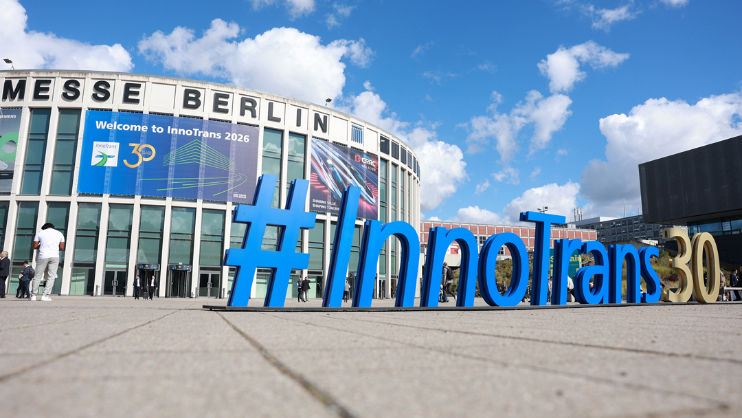 Der Eingang der Messe Berlin. Eine runde Glasfassade, am oberen Rand steht Berlin Messe. Auf dem Platz davor stehen mit riesige 3D-Buchstaben in blau, die das Wort innotrans bilden.